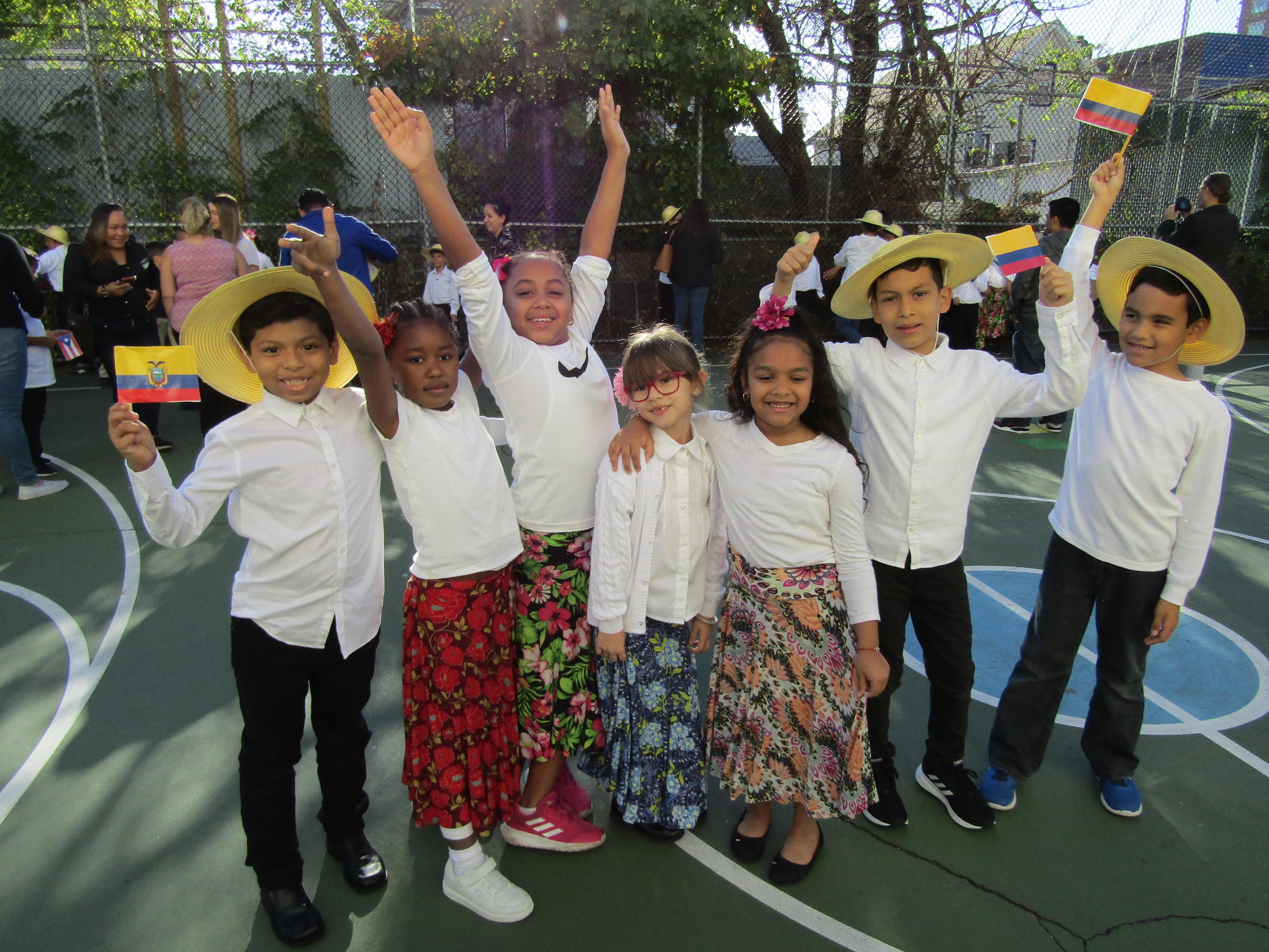 a group of boys and girls dressed in their performance costume with hands up in the air