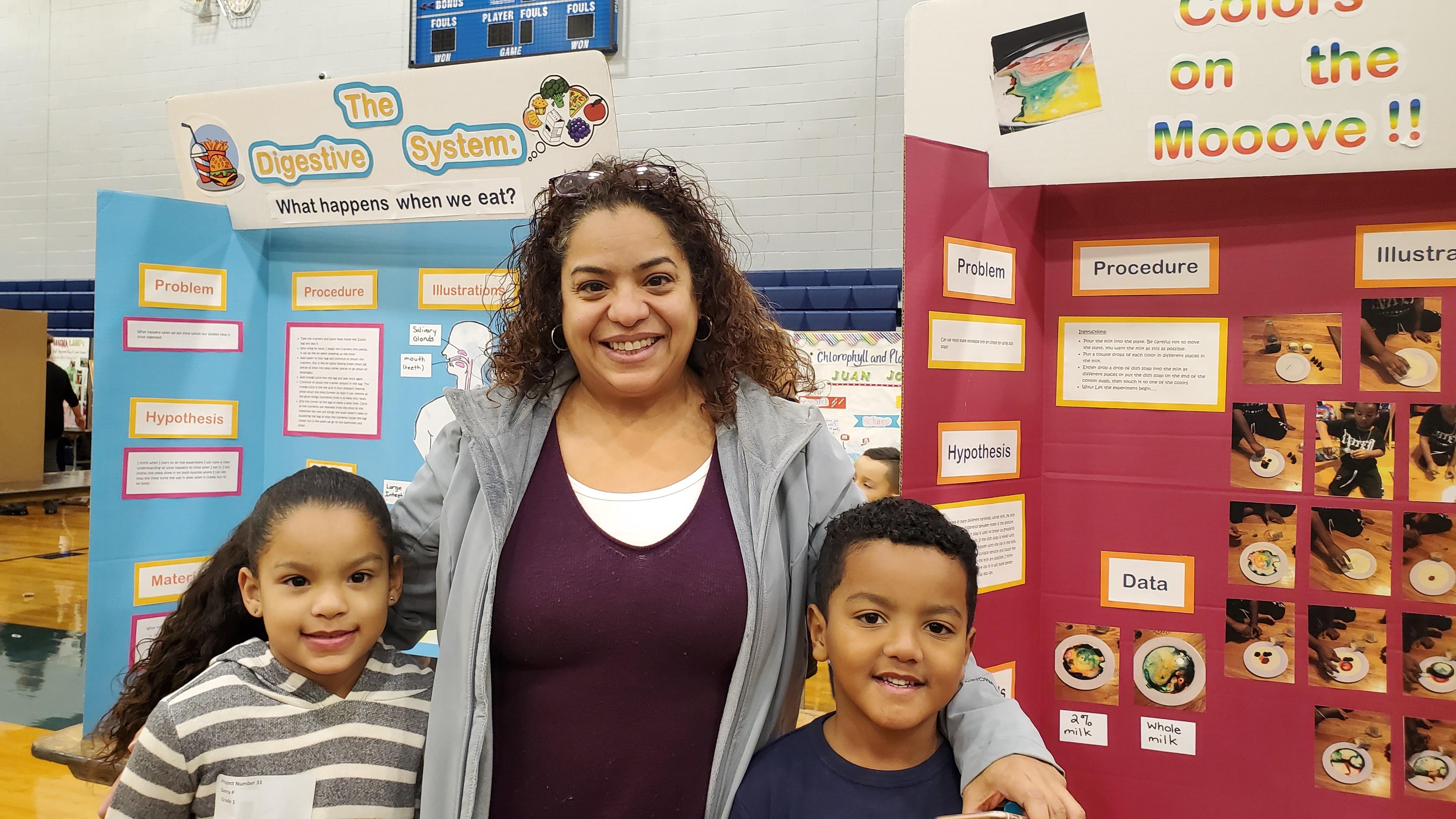 Sussa & Samuel P. with their mom in front of their science boards