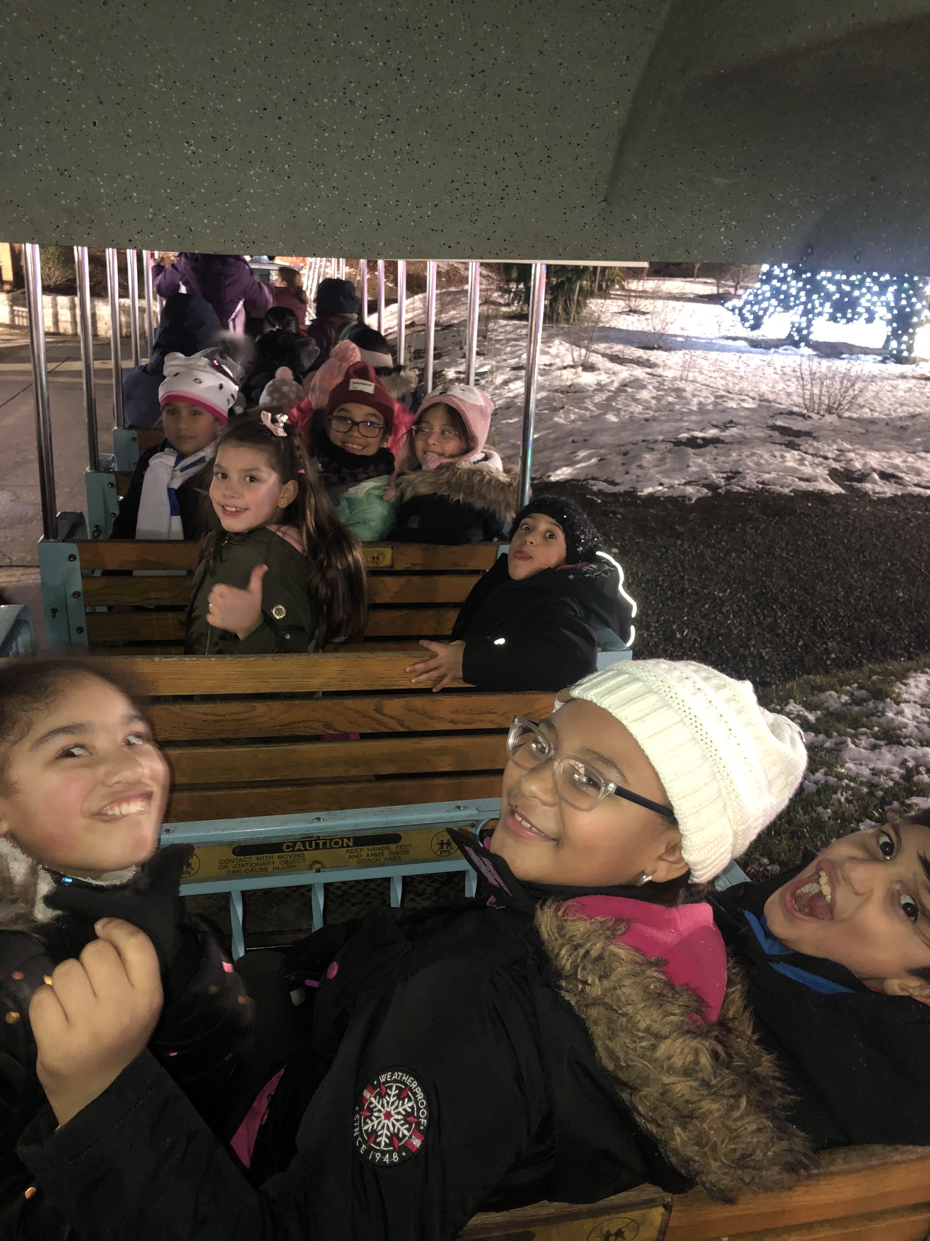 group of kids smiling while on the little red train