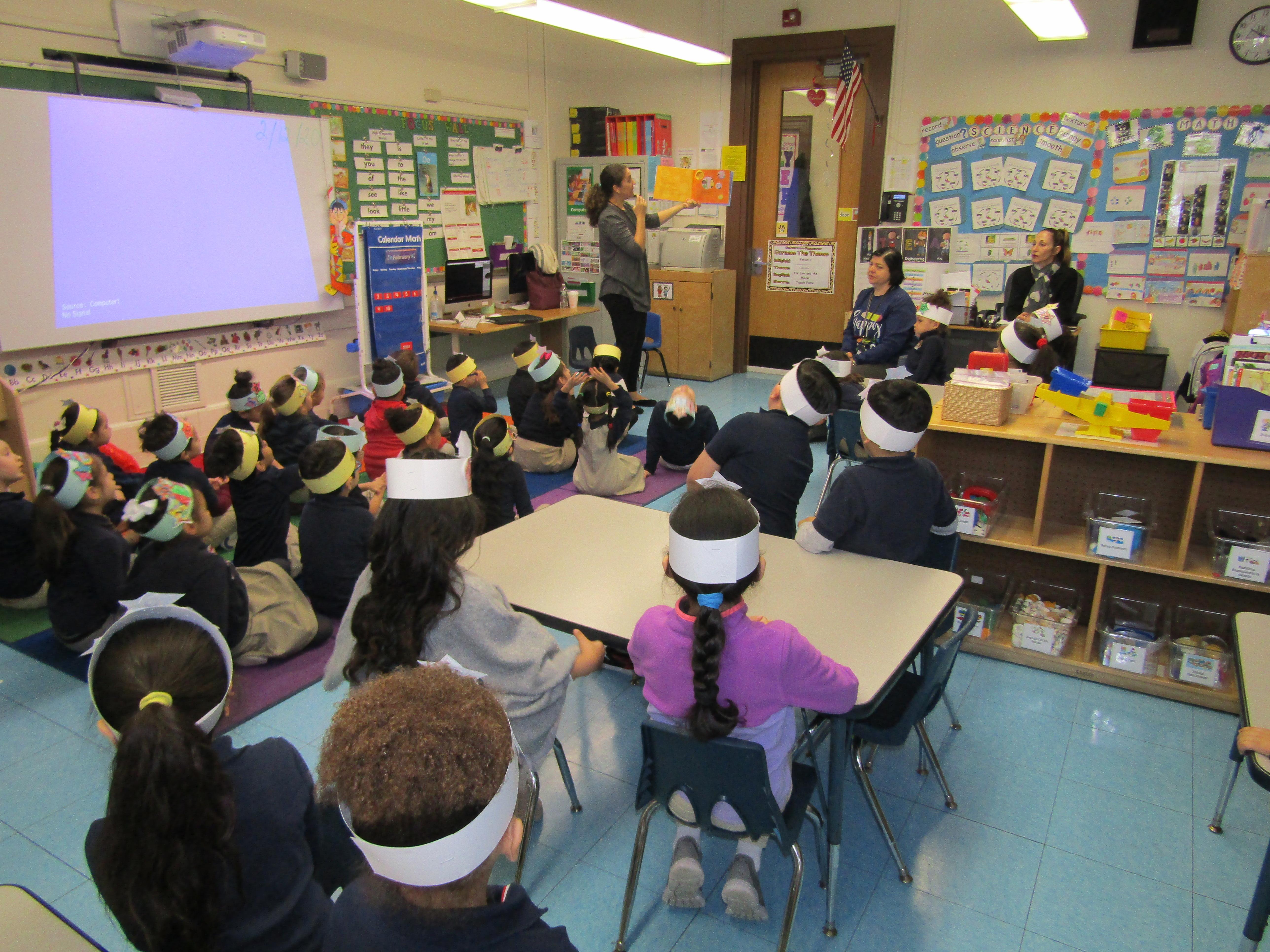students listening to teacher reading a book