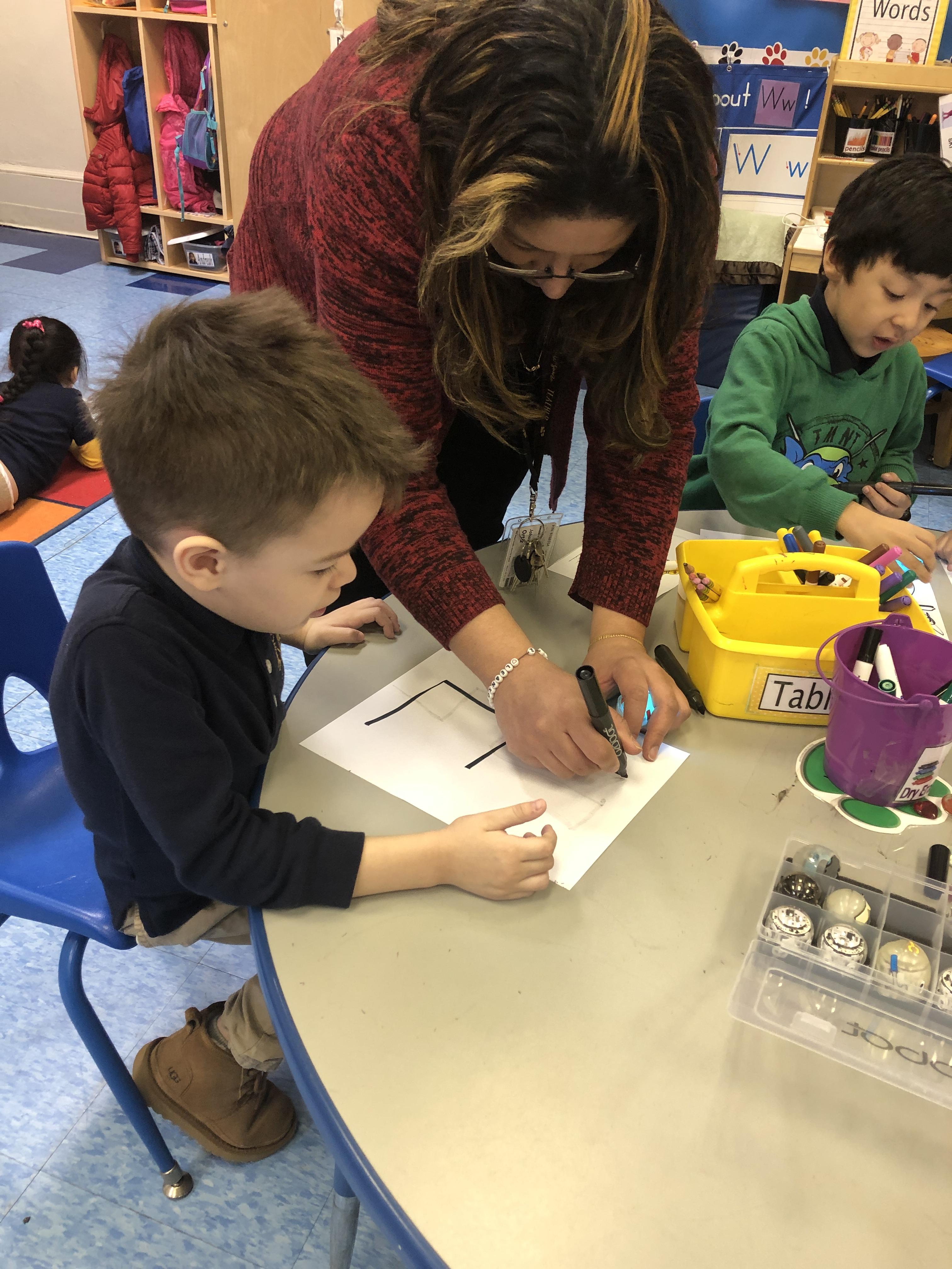 Ms. Ortiz at a table with several drawing coding lines