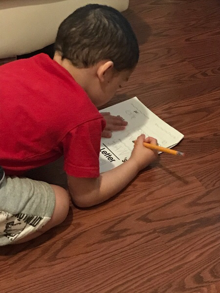 boy on the floor doing his work from home